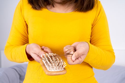 Hair fall problem, closeup hand holding comb and problem hair. Healthcare medical or daily life concept.