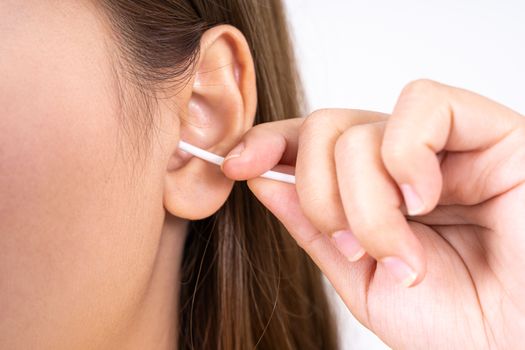 woman cleaning her ear with a cotton swab. A woman suffered an infection after using the sticks incorrectly.