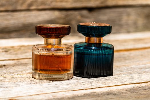 Elegant perfume bottles isolated on wooden background with copy space.