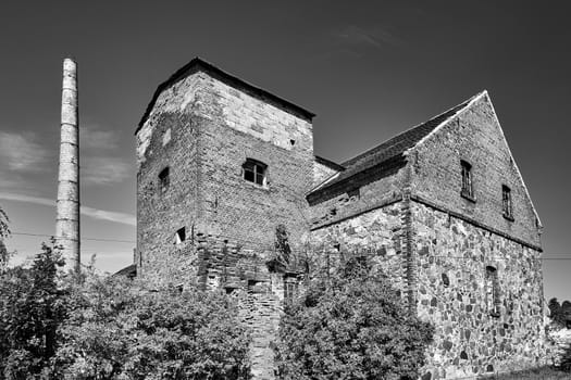 Buildings of a closed stone and brick distillery in the village of Trzemeszno Lubuskie in Poland, black and white