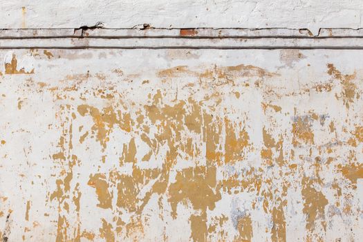 Shabby flat plaster and painted wall with big yellow under layer spots.