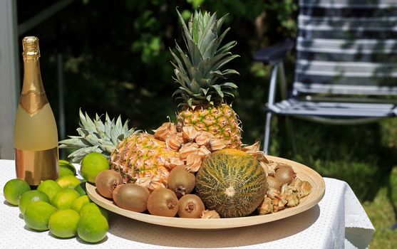 Outdoor table with fruit bowl and champagne bottle