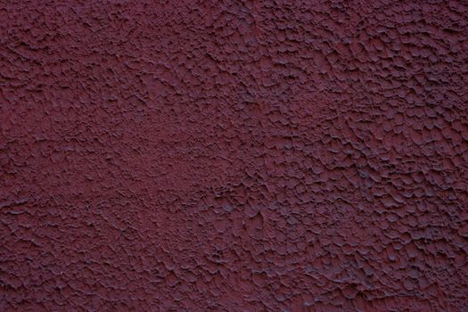 Rough decorative relief . Maroon decorative plastered wall. Maroon wall background.