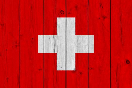 Switzerland flag painted on old wood plank. Patriotic background. National flag of Switzerland