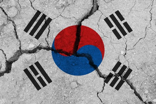 South korea flag on the cracked earth. National flag of South korea. Earthquake or drought concept