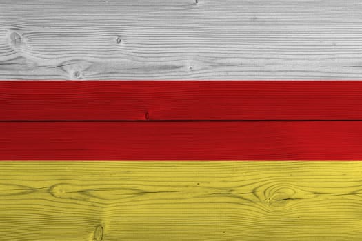 South ossetia flag painted on old wood plank. Patriotic background. National flag of South ossetia