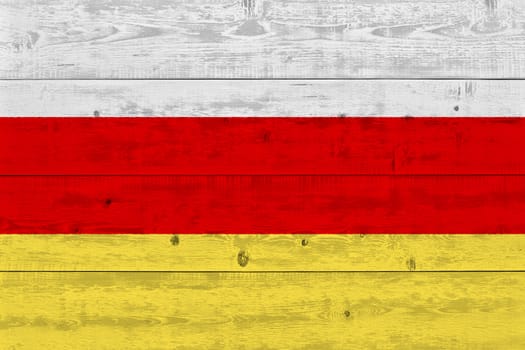 South ossetia flag painted on old wood plank. Patriotic background. National flag of South ossetia