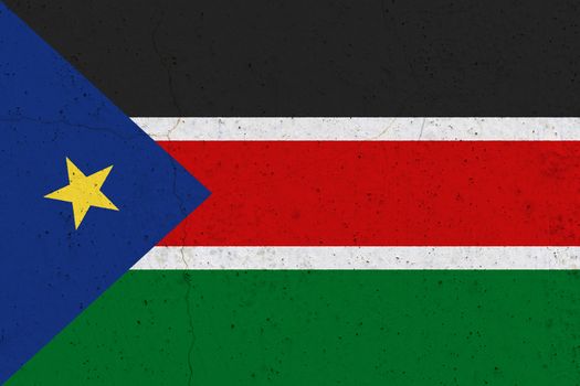 South Sudan flag on concrete wall. Patriotic grunge background. National flag of South Sudan