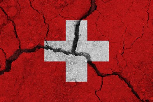 Switzerland flag on the cracked earth. National flag of Switzerland. Earthquake or drought concept
