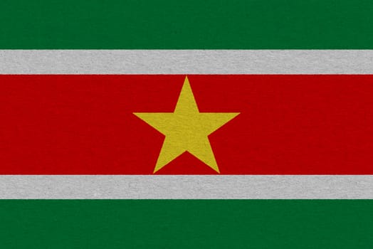 Suriname flag painted on paper. Patriotic background. National flag of Suriname