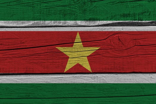 Suriname flag painted on old wood plank. Patriotic background. National flag of Suriname