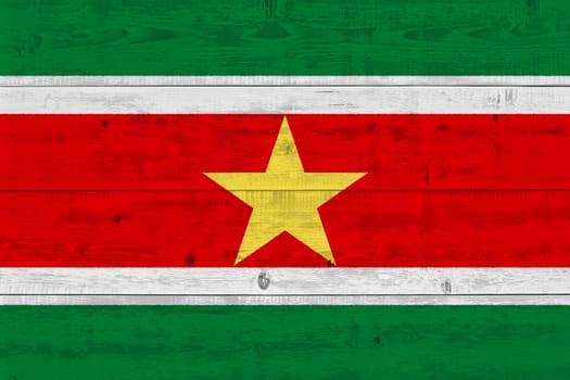 Suriname flag painted on old wood plank. Patriotic background. National flag of Suriname