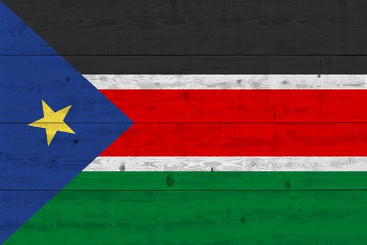 South Sudan flag painted on old wood plank. Patriotic background. National flag of South Sudan