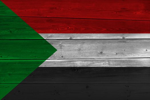 Sudan flag painted on old wood plank. Patriotic background. National flag of Sudan