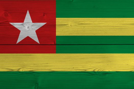 Togo flag painted on old wood plank. Patriotic background. National flag of Togo