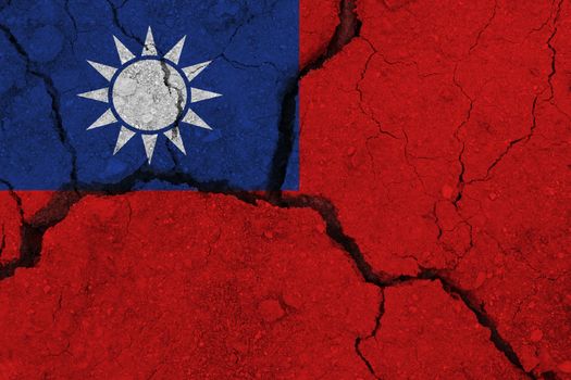 Taiwan flag on the cracked earth. National flag of Taiwan. Earthquake or drought concept