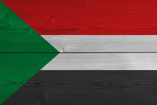 Sudan flag painted on old wood plank. Patriotic background. National flag of Sudan