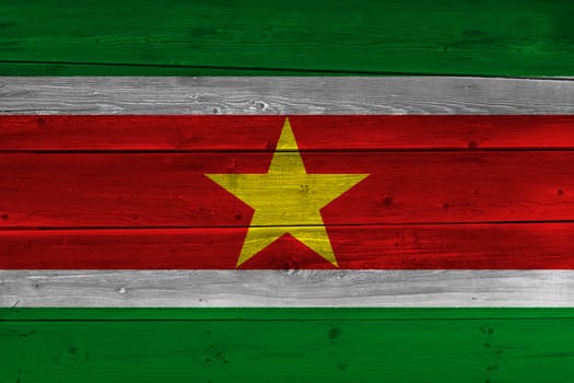 Suriname flag painted on old wood plank. Patriotic background. National flag of Suriname