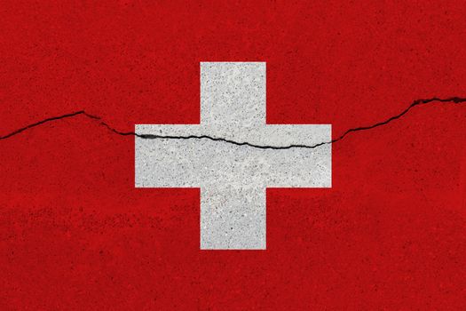 Switzerland flag on concrete wall with crack. Patriotic grunge background. National flag of Switzerland