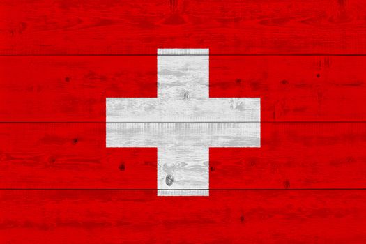 Switzerland flag painted on old wood plank. Patriotic background. National flag of Switzerland