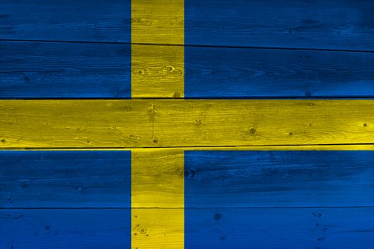 Sweden flag painted on old wood plank. Patriotic background. National flag of Sweden