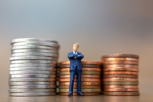 Miniature people: Small businessmen standing with stack of coins , Business Growth concept.