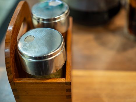 Pepper jars in a wooden box on the dining table.