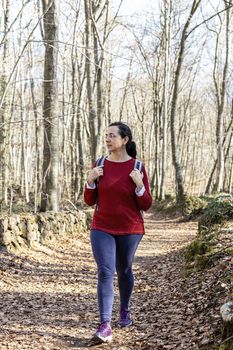 Sporty Spanish woman walking on the pathway in the forest in springtime, Garrotxa Volcanic Zone Natural Park
