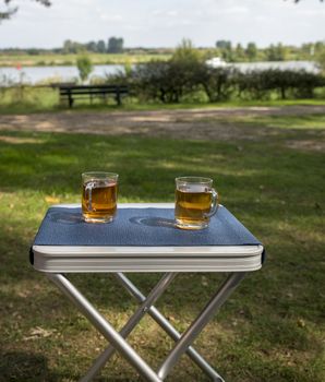 two glasses of tea during afternoon break outside on a table on the river Maas