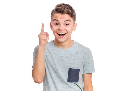 Cute teen boy pointing up, gesturing idea or doing number one gesture.