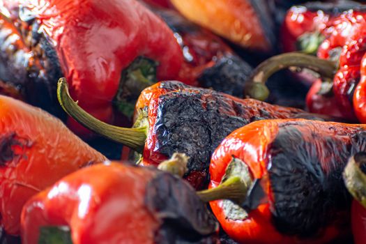 Red peppers roasting on a wood-fired stove in preparation for making ajvar, a traditional serbian dish