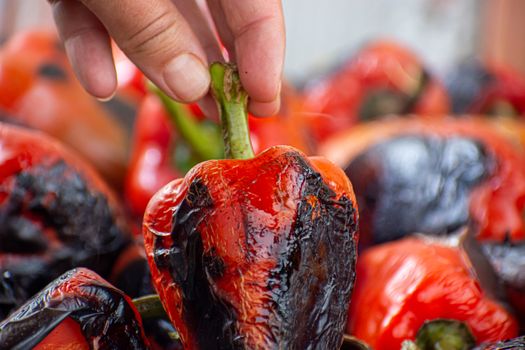 Red peppers roasting on a wood-fired stove in preparation for making ajvar, a traditional serbian dish