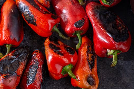 Red peppers roasting on a wood-fired stove in preparation for making ajvar, a traditional serbian dish