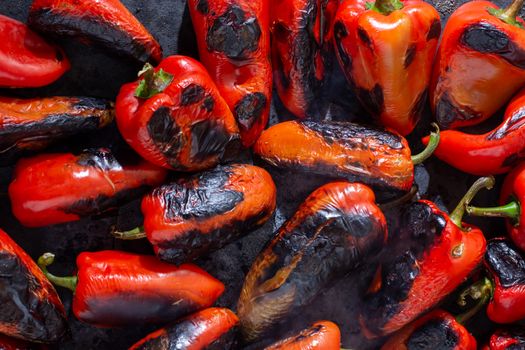 Red peppers roasting on a wood-fired stove in preparation for making ajvar, a traditional serbian dish