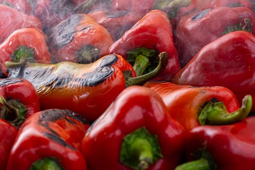 Red peppers roasting on a wood-fired stove in preparation for making ajvar, a traditional serbian dish