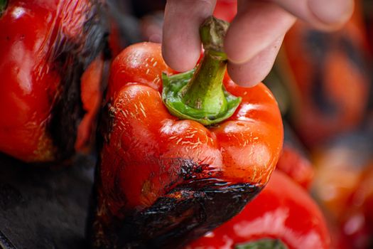 Red peppers roasting on a wood-fired stove in preparation for making ajvar, a traditional serbian dish