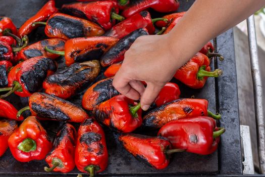 Red peppers roasting on a wood-fired stove in preparation for making ajvar, a traditional serbian dish