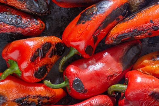 Red peppers roasting on a wood-fired stove in preparation for making ajvar, a traditional serbian dish