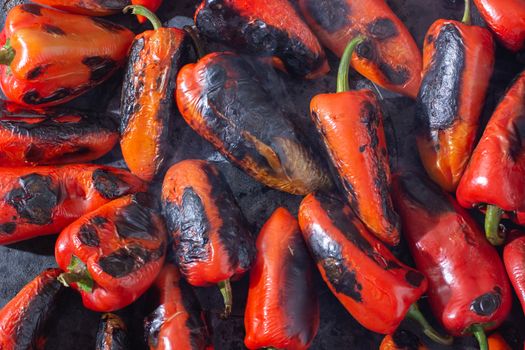 Red peppers roasting on a wood-fired stove in preparation for making ajvar, a traditional serbian dish