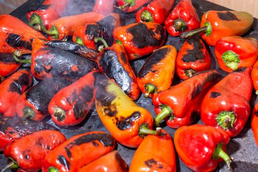 Red peppers roasting on a wood-fired stove in preparation for making ajvar, a traditional serbian dish