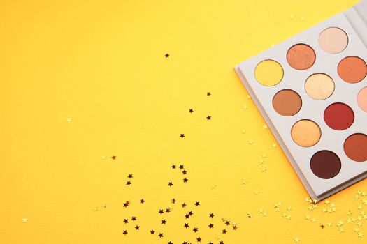 Eyeshadows on a yellow background professional cosmetics makeup brushes soft sponge fashion glasses. High quality photo