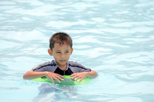 Asian boy in swimwear, swimming fun in the pool.