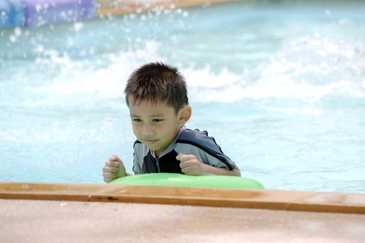 Asian boy in swimwear, swimming fun in the pool.