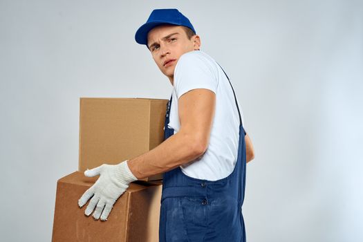 working man in uniform with boxes in his hands delivery loader lifestyle. High quality photo