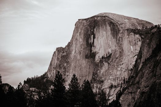The view from within Yosemite Valley and rock detail of surrounding rock faces on a stormy day in California, USA