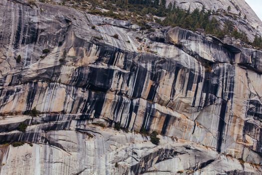 The view from within Yosemite Valley and rock detail of surrounding rock faces on a stormy day in California, USA