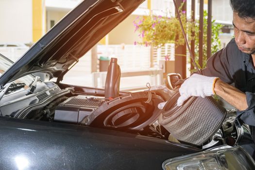 The technician removes the car's air filter for inspection and cleaning, Automotive industry and garage concepts.