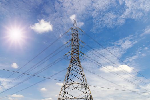 Closeup the high voltage towers with clouds sky and sun background.