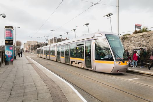 Dublin, Ireland - February 13, 2019: Passengers in a tram station where a train is stopped on a winter day