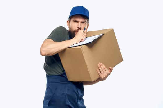 Working male courier with box in hand documents delivery service light background. High quality photo